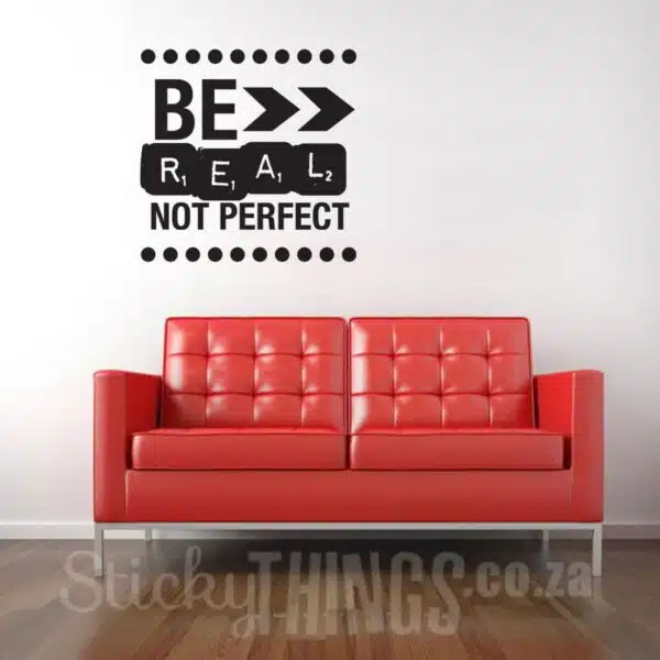 Be Real Not Perfect Wall Vinyl above red couch