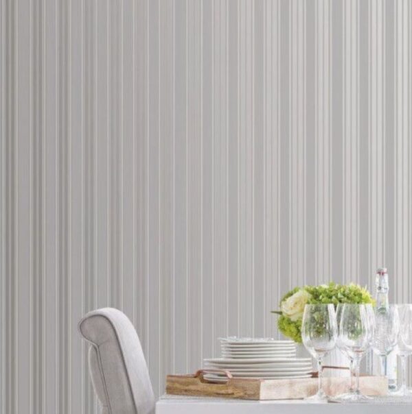 This picture features the silver striped wallpaper in the background with a dining table with sparkley glasses and a grey velvet dining chair.